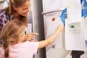 a family using a chore chart on a refrigerator