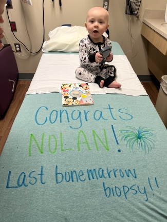 Nolan sitting on bed with congratulations message