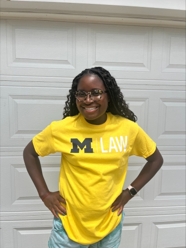 Awo in yellow University of Michigan Law shirt