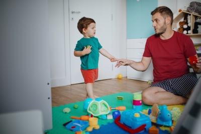 father and son playing with toys