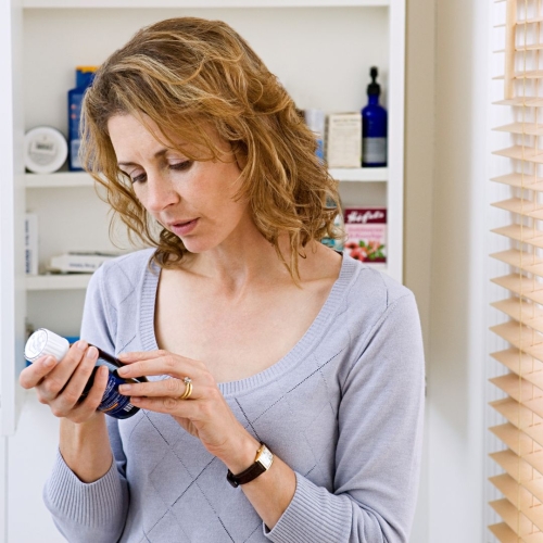 Women studying medication bottle