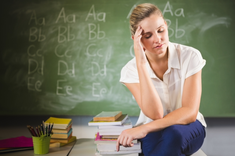 stressed teacher in front of a chalkboard