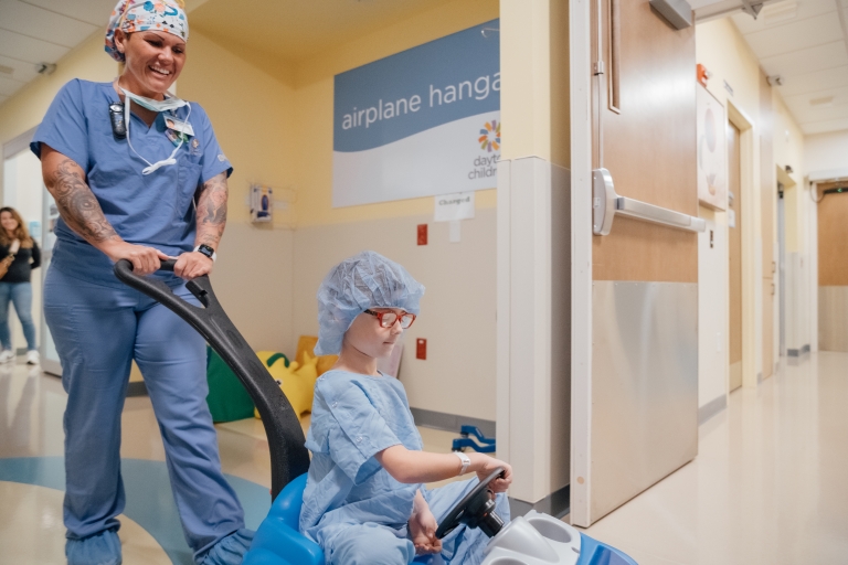 Little boy riding to surgery in a blue car