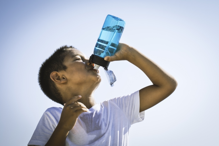 Boy drinking water hot weather