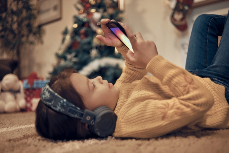 child with cell phone and headphones for Christmas