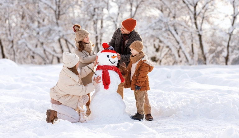 family of four building a snowman together