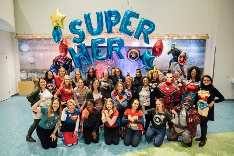 group of employees posed and dressed up for superhero day