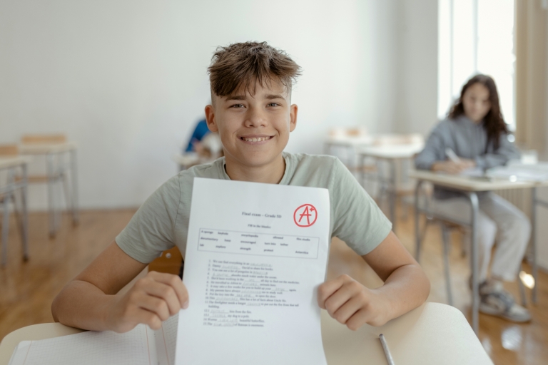 boy showing his good grade on a test