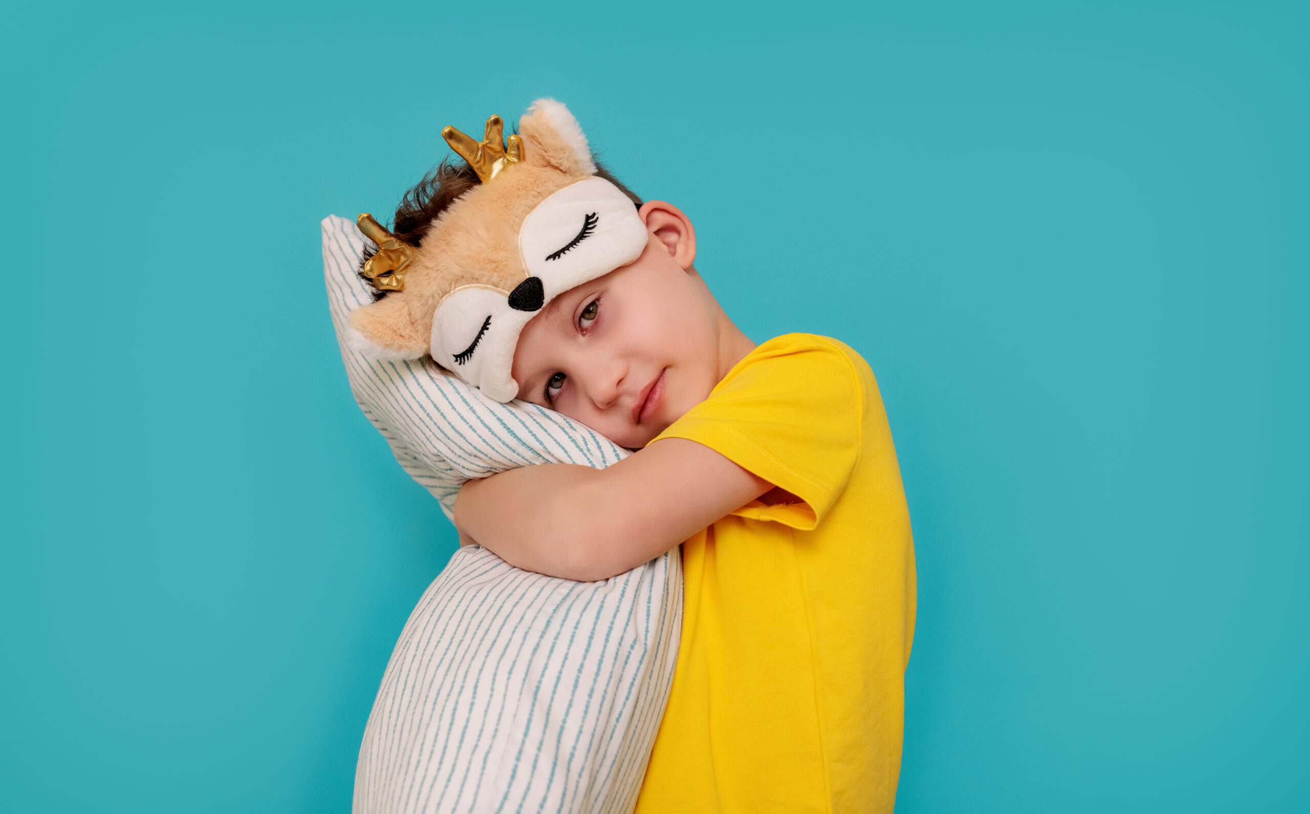 Sleepy child hugs the pillow.