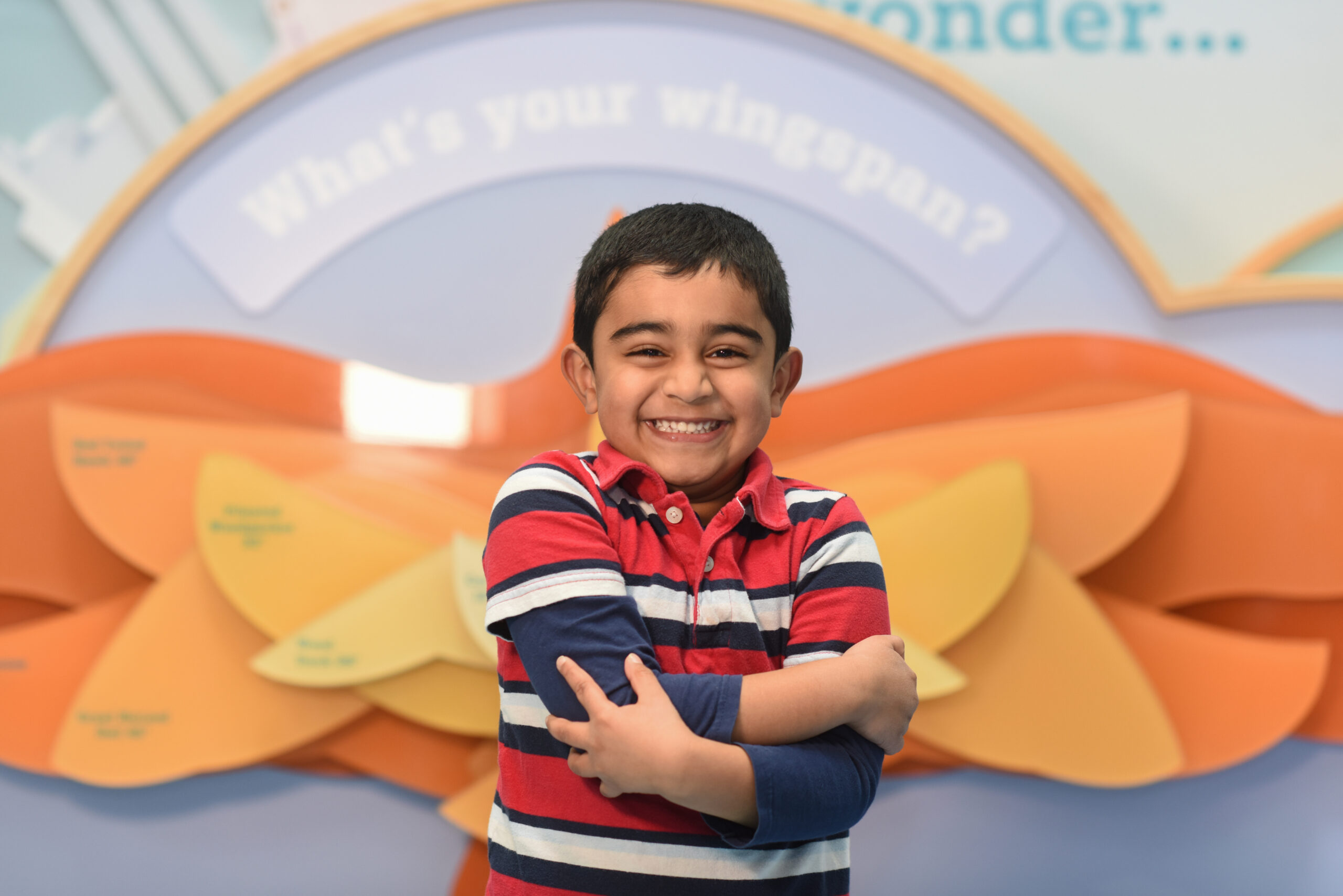 Smiling child holding colorful paper hearts to support donation efforts.