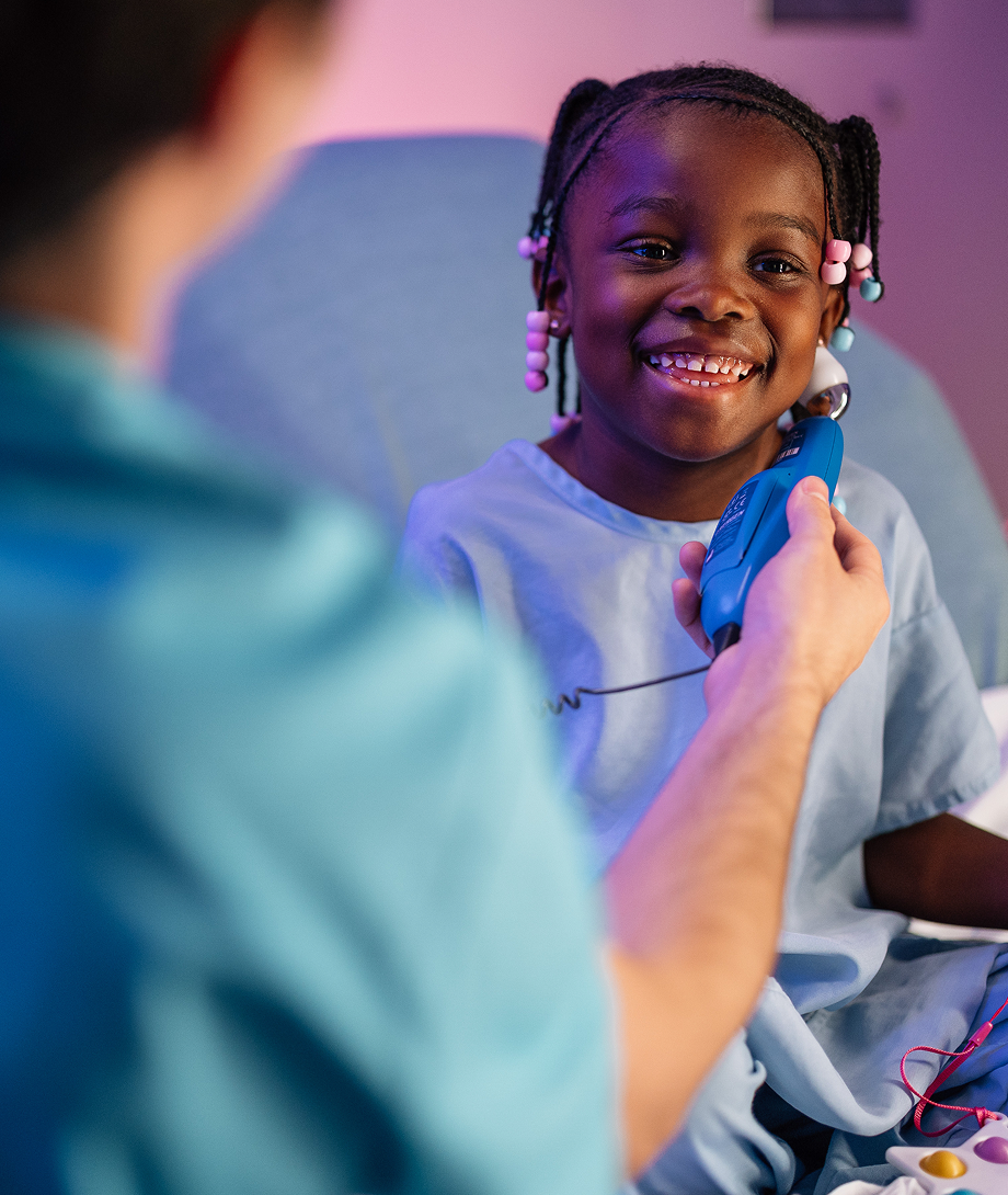 Smiling child receiving a medical check-up at Dayton Children’s Hospital.