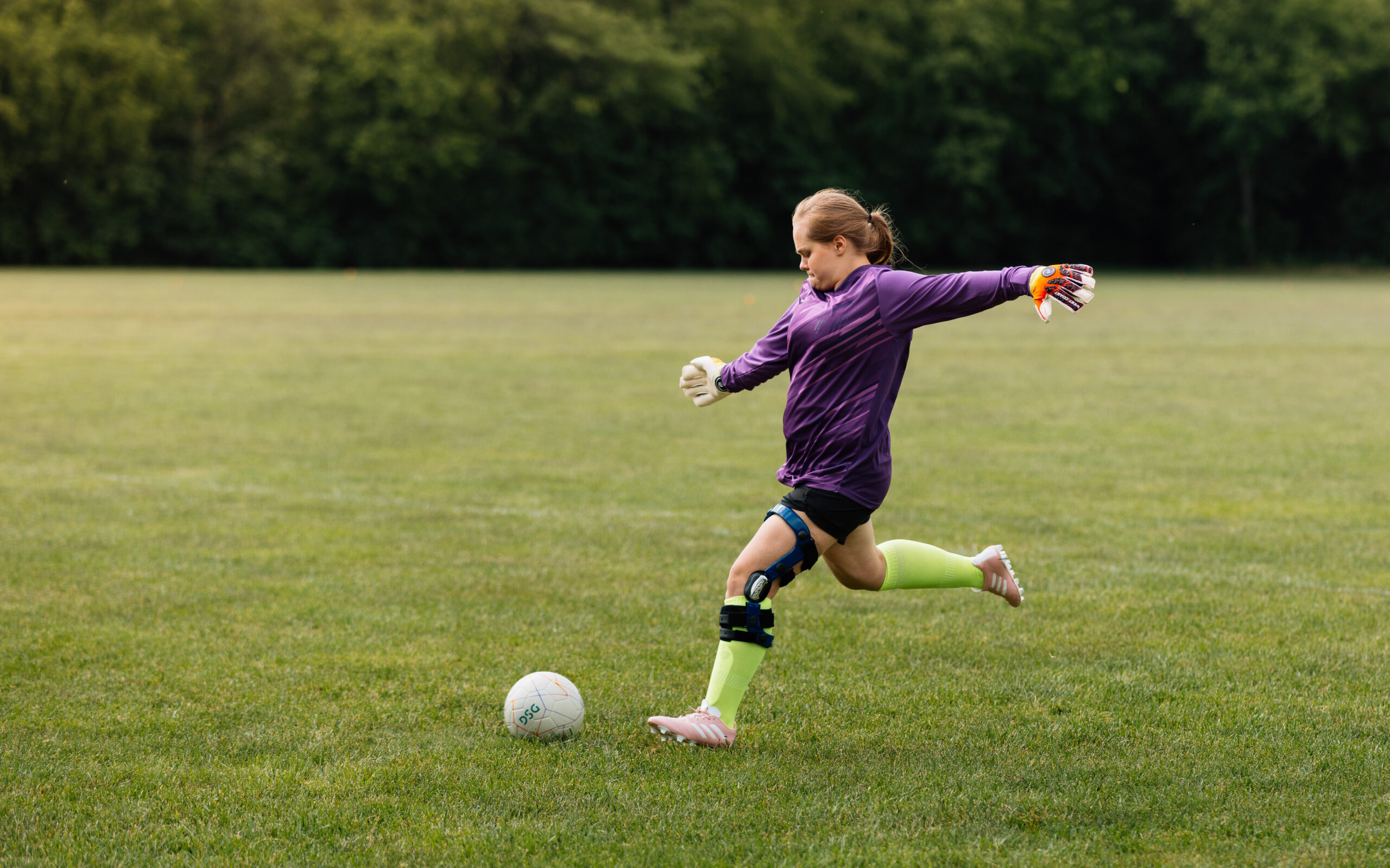 female soccer player lines up a kick on the field