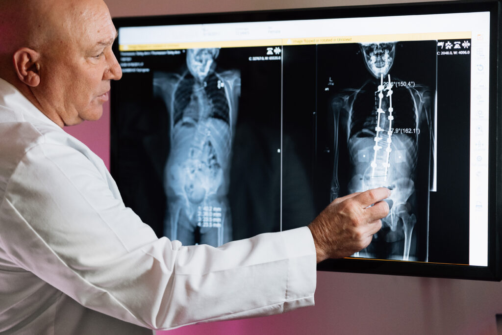 orthopedic doctor pointing to an xray on a screen

