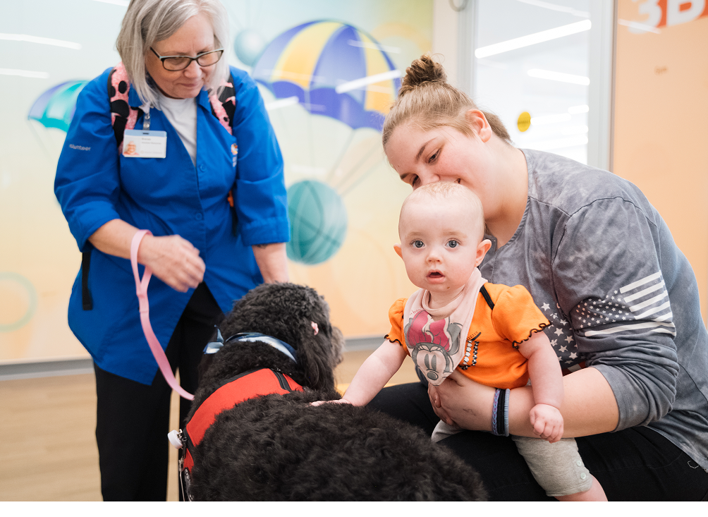 Pet therapy volunteer takes her dog around to be pet by patients while waiting for their appointment.