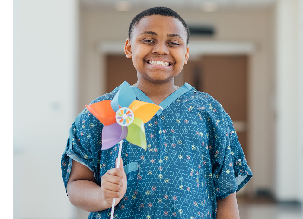 Smiling child holding a colorful pinwheel.