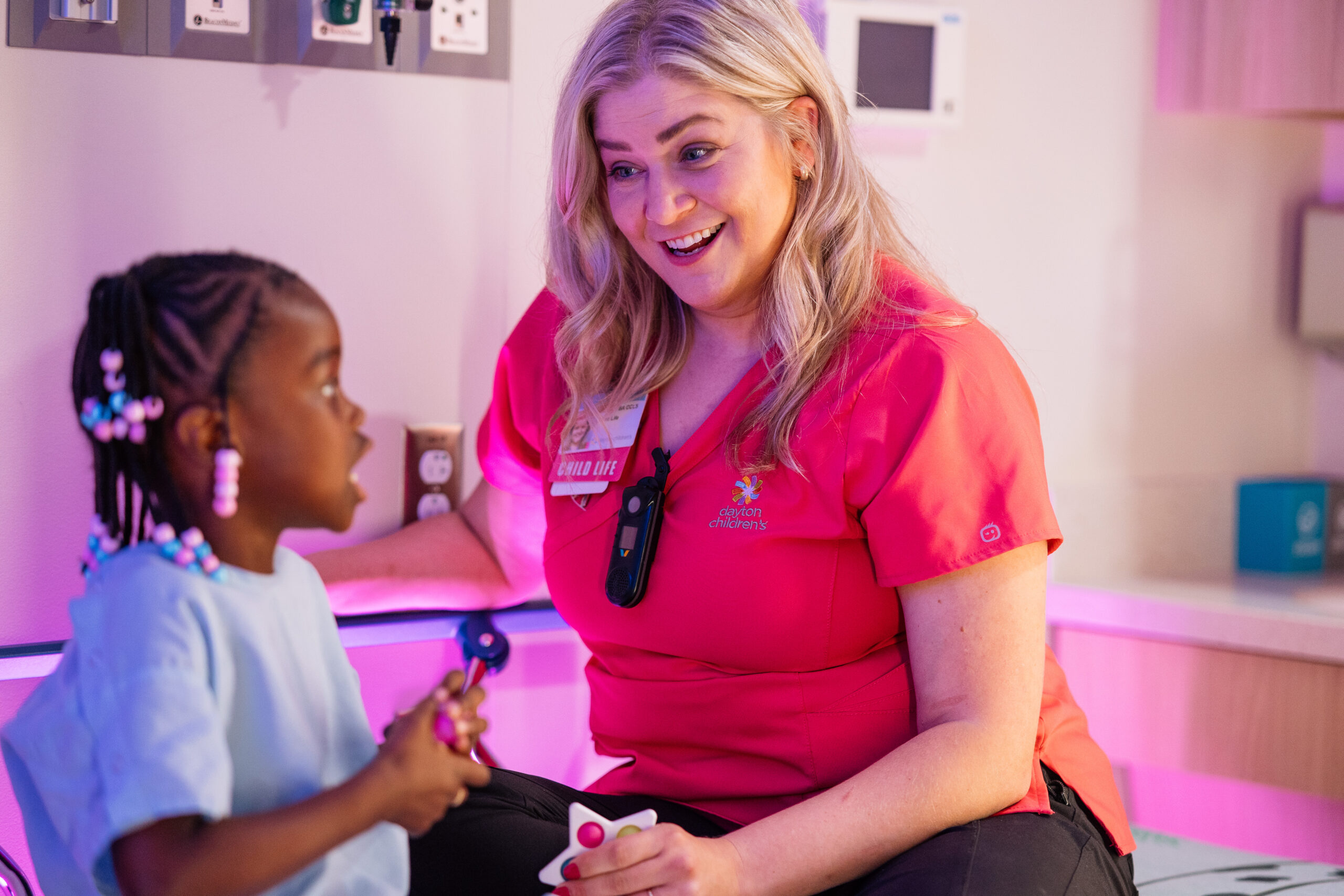 A child life specialist helps relieve the tension around an upcoming surgery by engaging the patient in fun conversation, making her laugh.