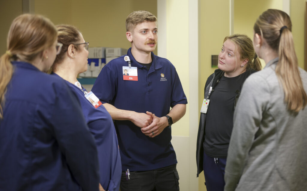 A team of RNs and staff discuss a patient’s complex care plan and how best to support the family.