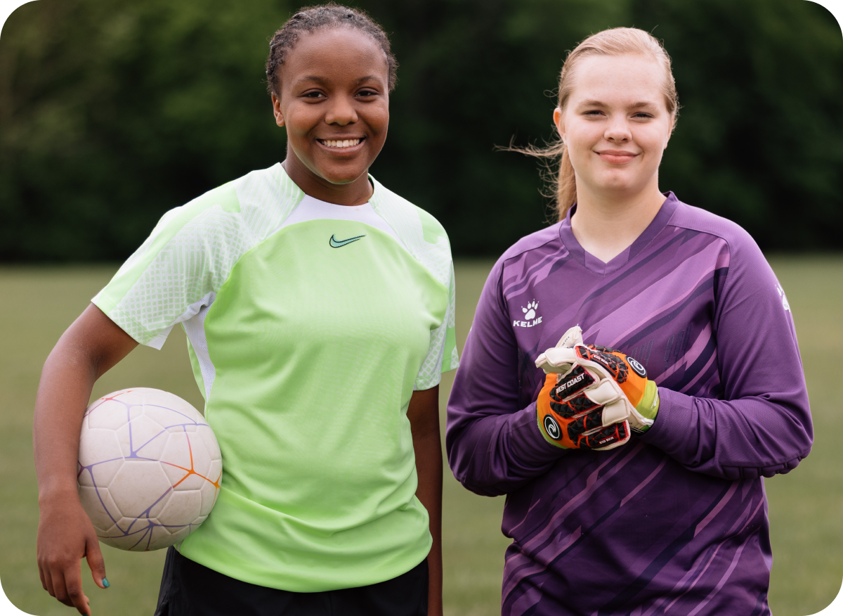 Two smiling youth soccer players holding soccer balls, representing community sponsorship support.
