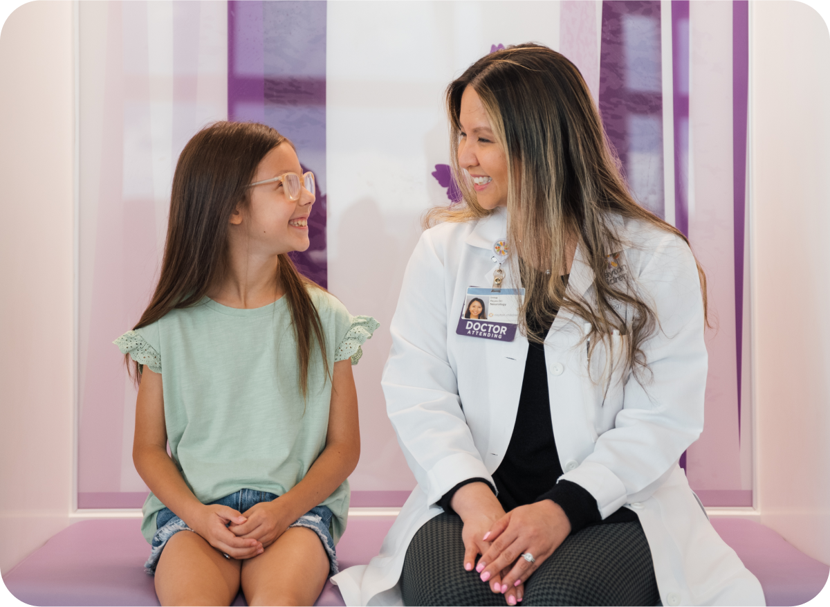 Young patient and healthcare provider smiling together in a clinic setting.