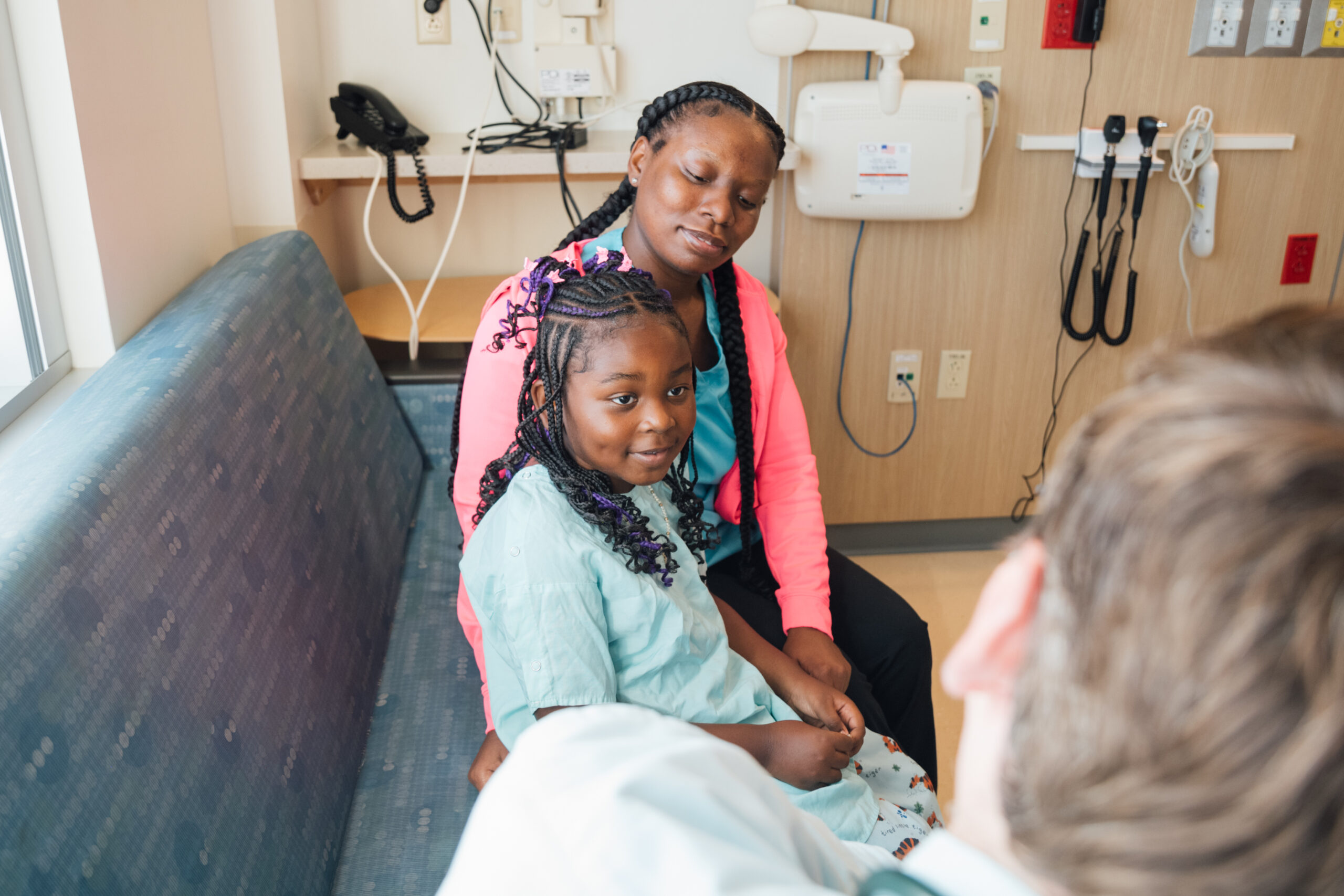Young girl and mom sitting in an inpatient room at Dayton Children’s, listening to the doctor’s recommendation for treatment.