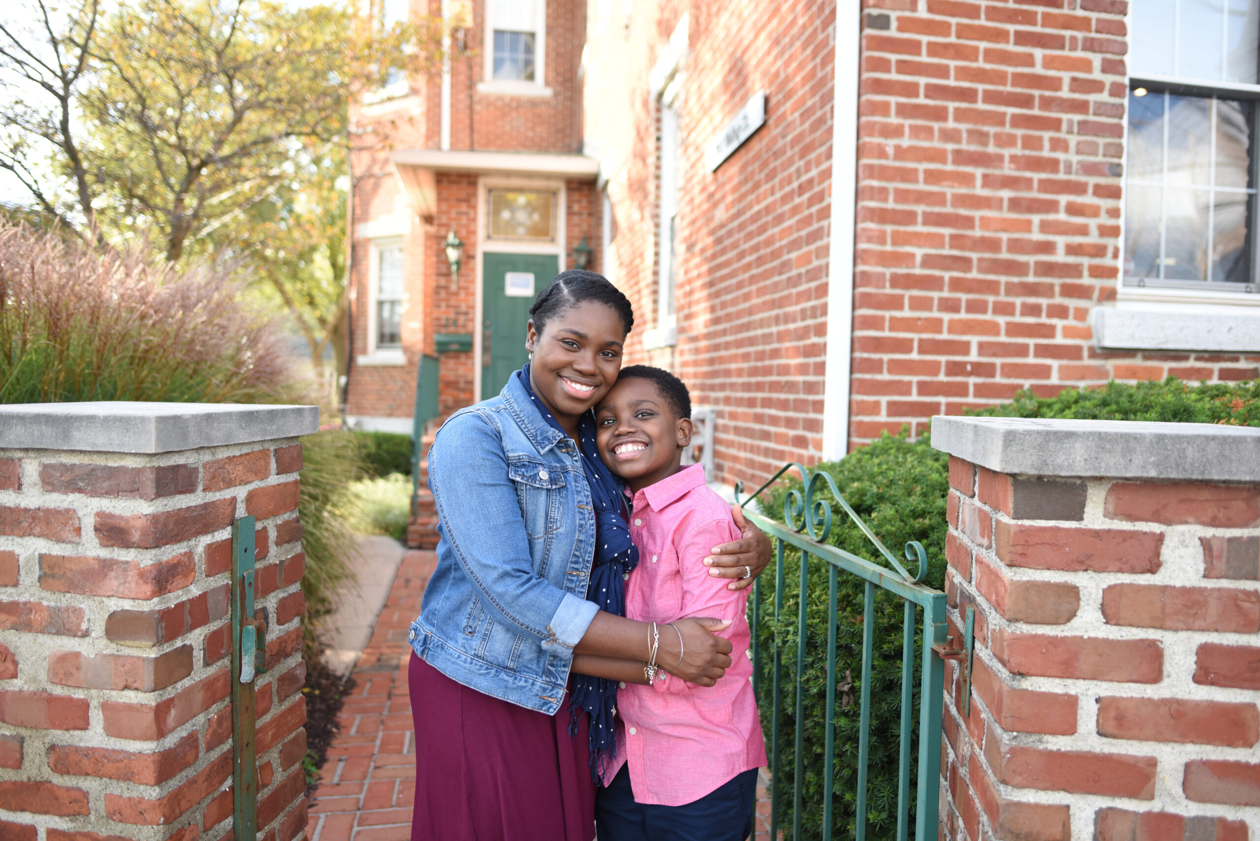 A mom and her son stand smiling outside, appreciative of the pain management that Dayton Children’s has provided for his sickle cell.