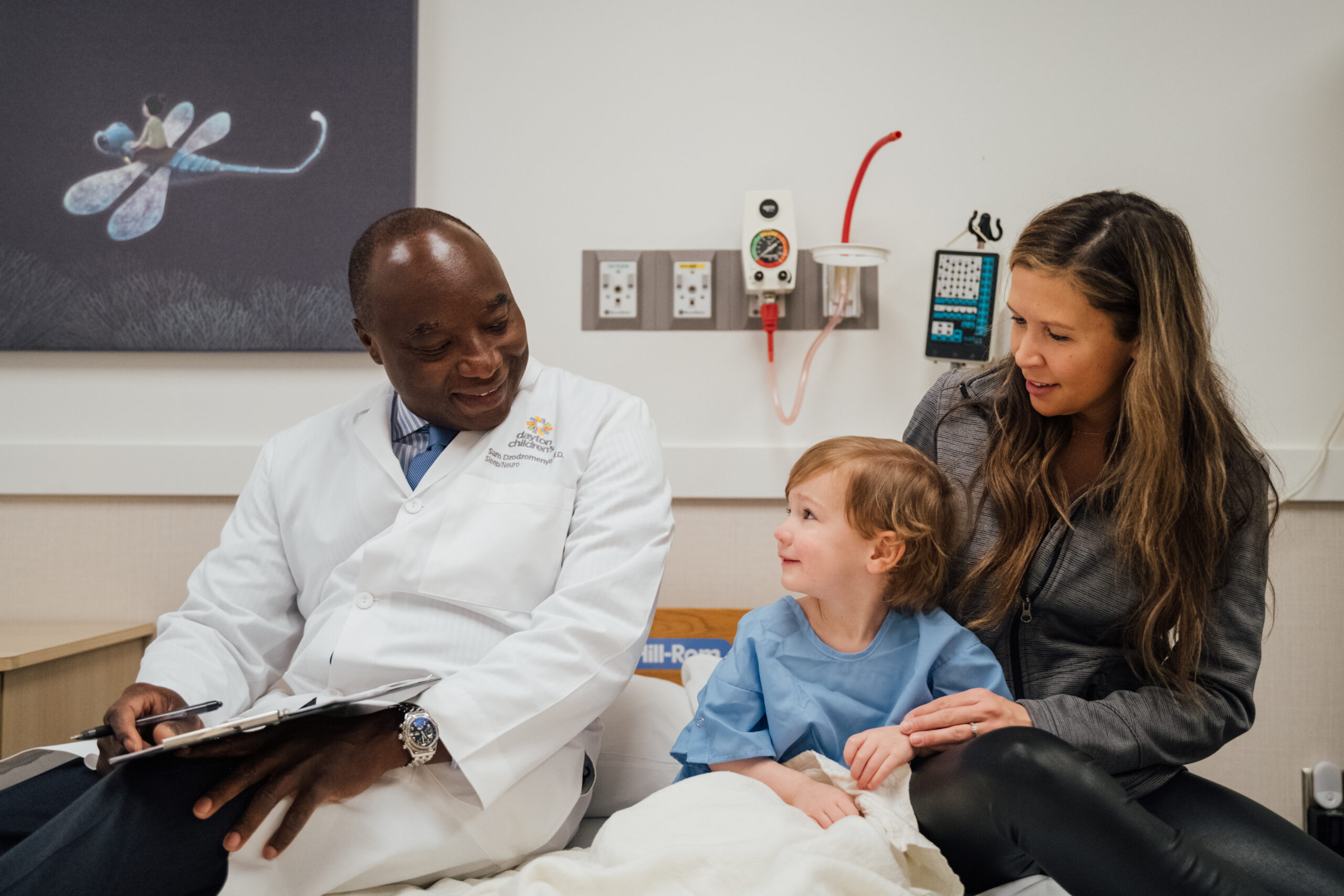 A boy being cared for by his doctor with his mother by his side at Dayton Children’s