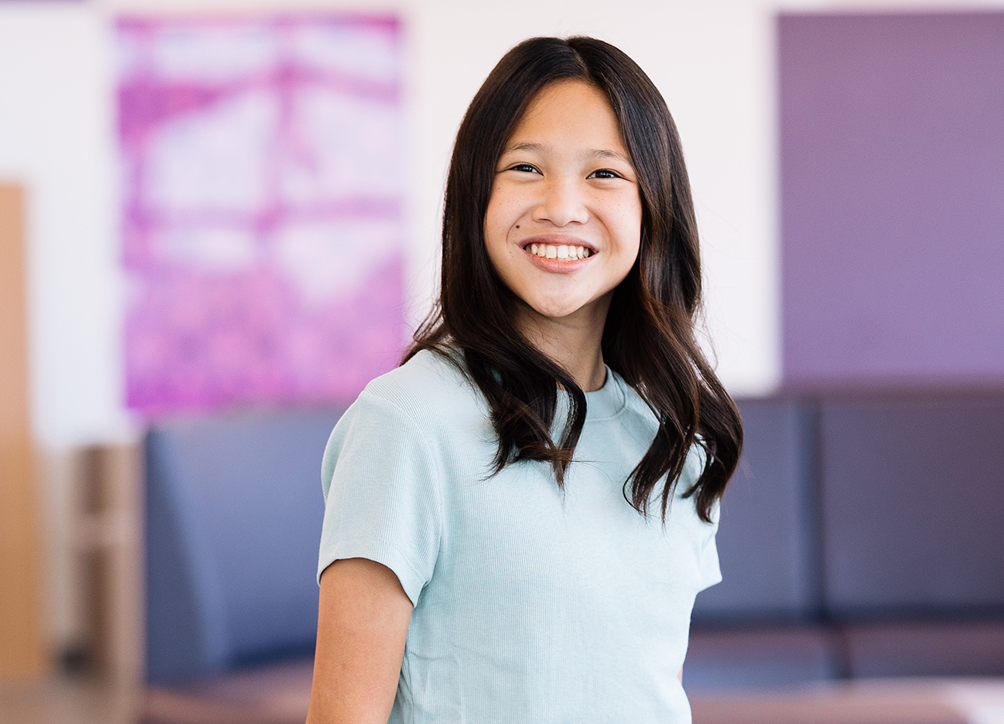 Smiling young patient standing in the hospital lobby at Dayton Children’s Hospital, representing quick and efficient care.