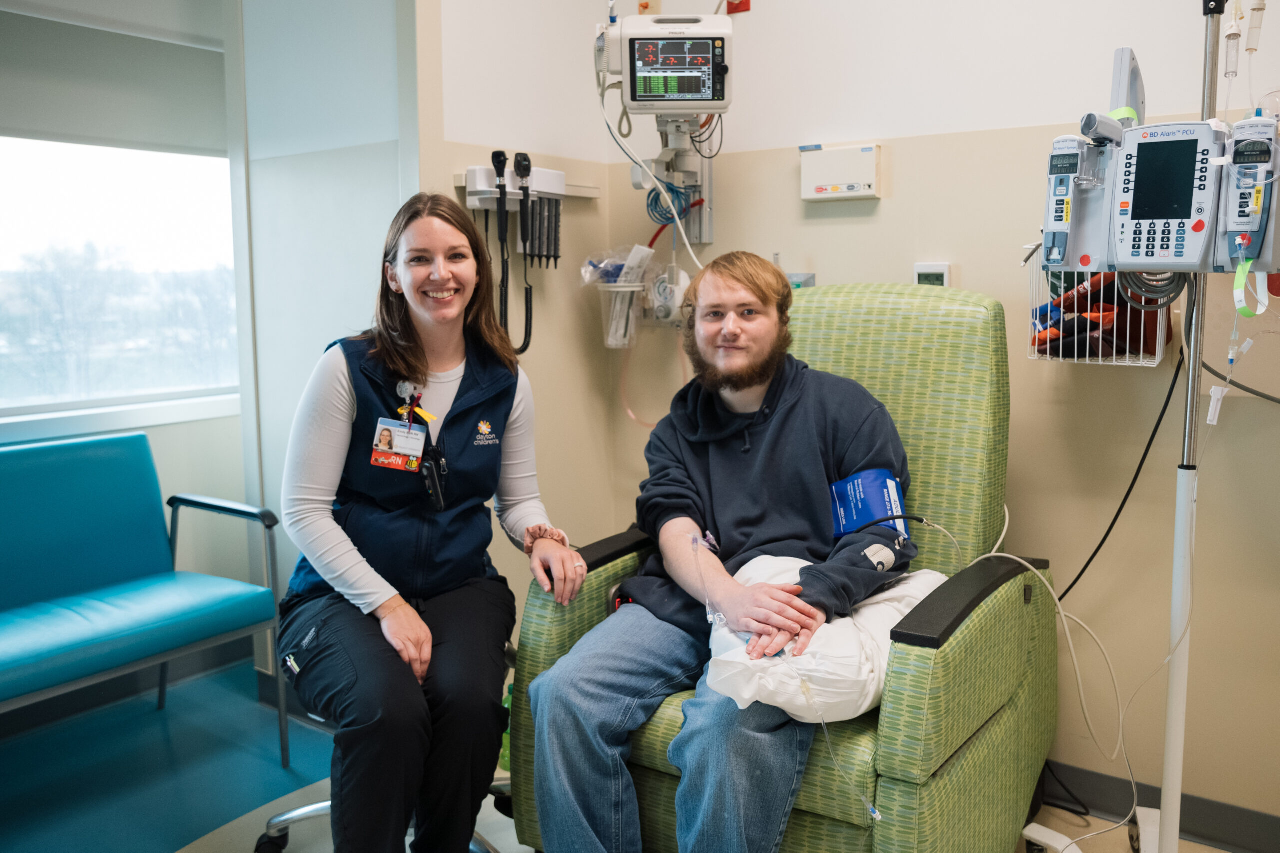 young adult male getting blood pressure checked at IBD Clinic with Dayton employee next to him