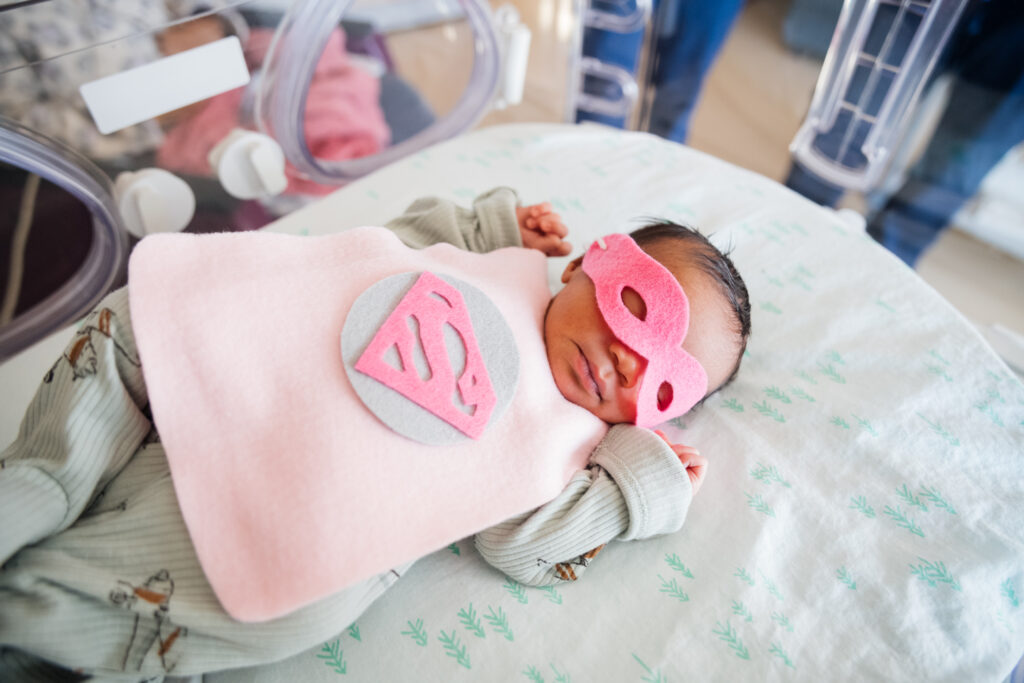 A NICU baby dressed up as Supergirl for superhero day at Dayton Children’s.