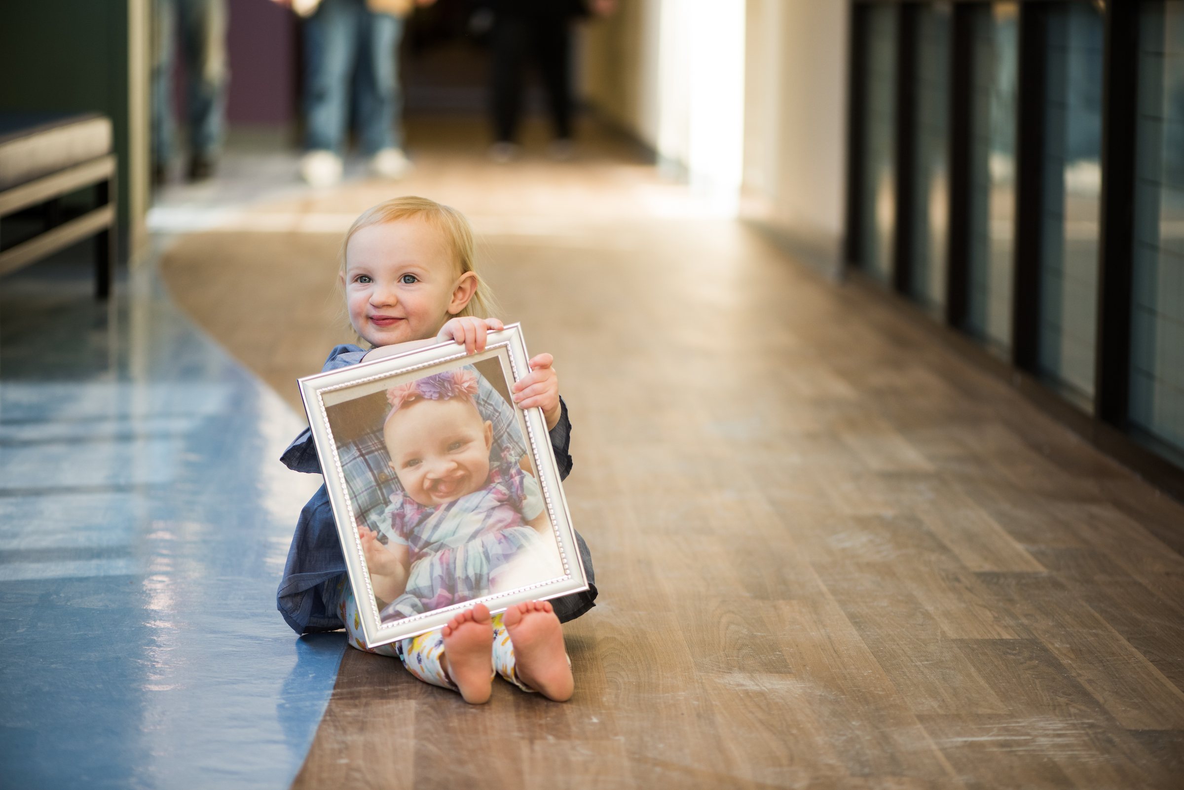 Little girl holding framed photo of herself with a cleft lip as a baby but after plastic and reconstruction surgery at Dayton Children’s her cleft lip was reconstructed 

