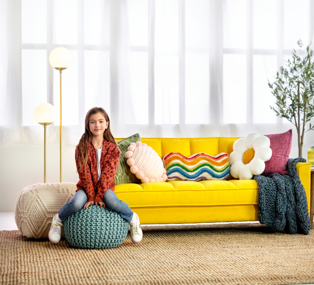 Young, preteen girl sitting in a bright, colorful decorated room, feeling safe and supported. 