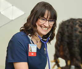 A pediatric nurse speaks warmly with a young patient, reflecting the dedication and compassion highlighted in the annual nursing report.