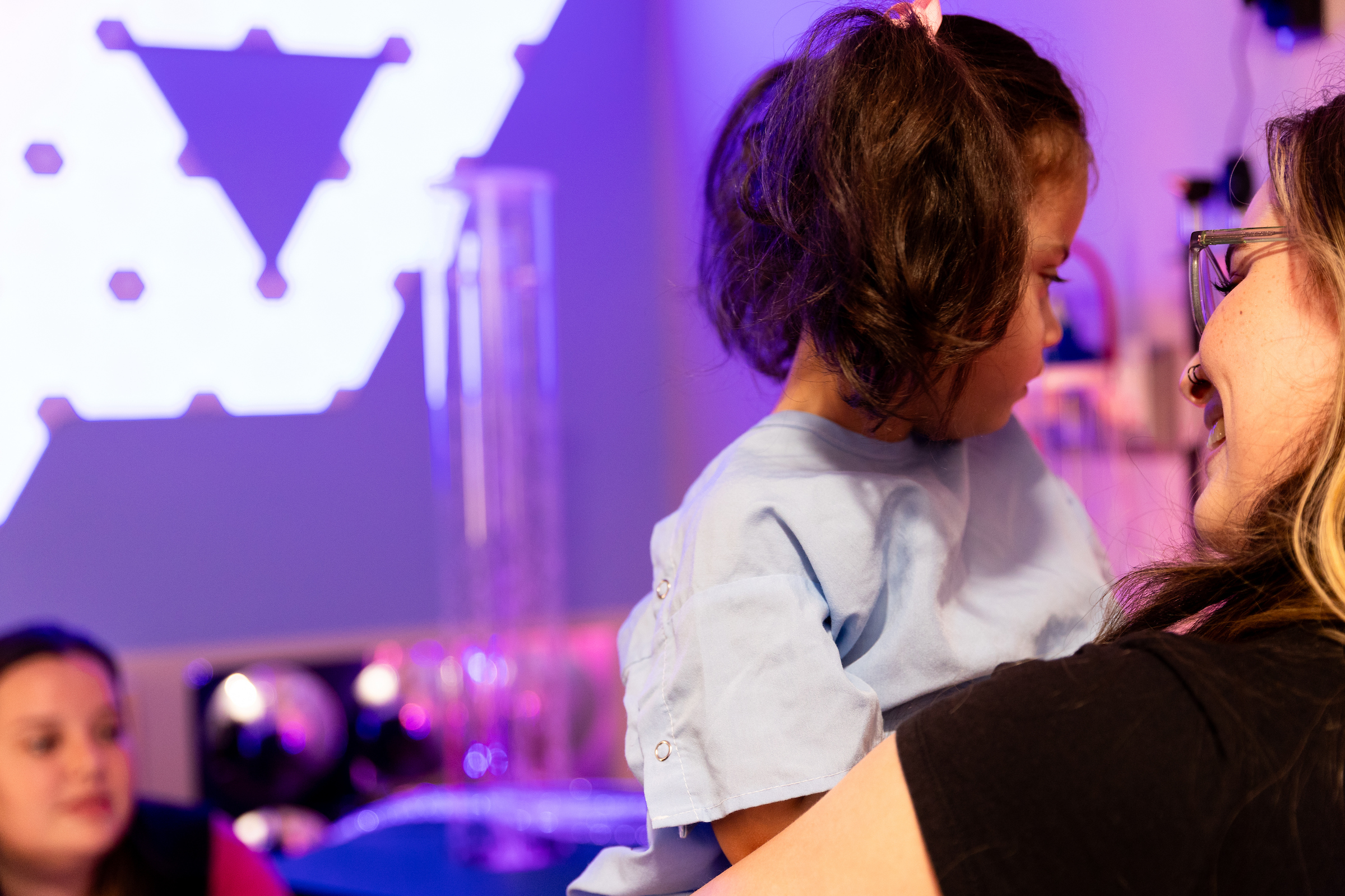 child feeling calm with mom and caregiver in sensory room while preparing for surgery.