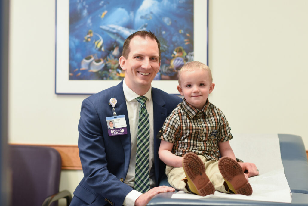 Dayton Children’s doctor smiling with a young boy.
