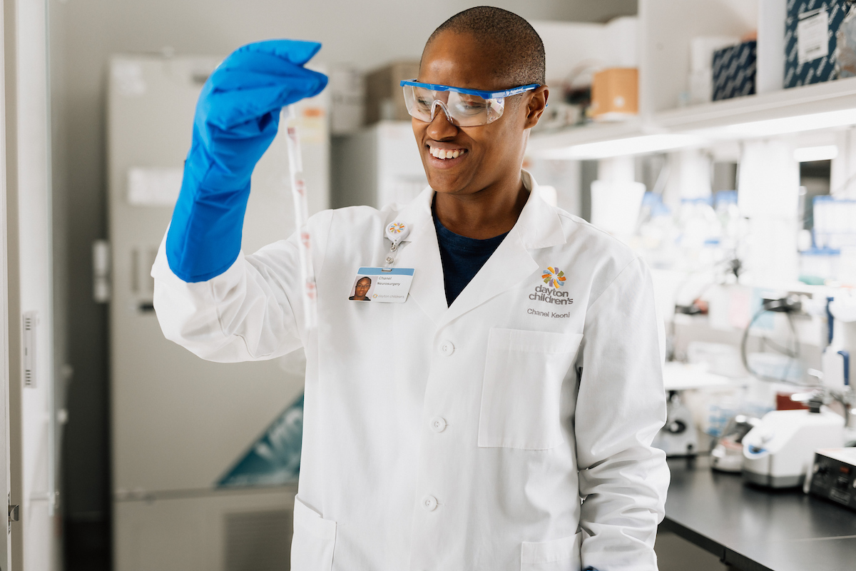Head researcher of the biobank smiles while examining a sample in the lab at Dayton Children’s Hospital.