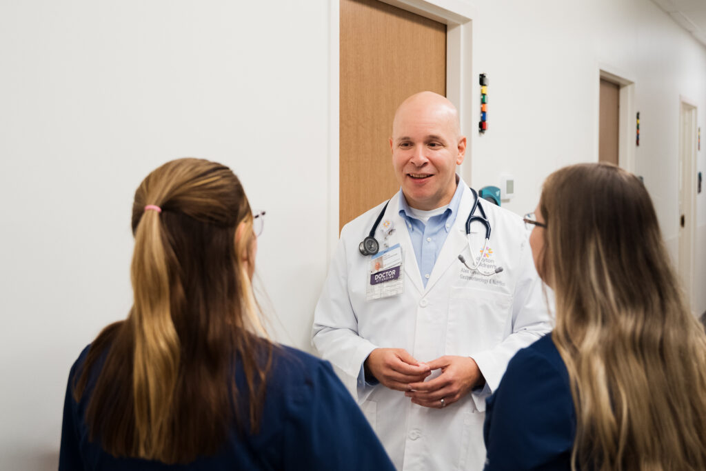 Doctor and staff discussing a grand rounds presentation about a complex case that will help them strengthen their practice.