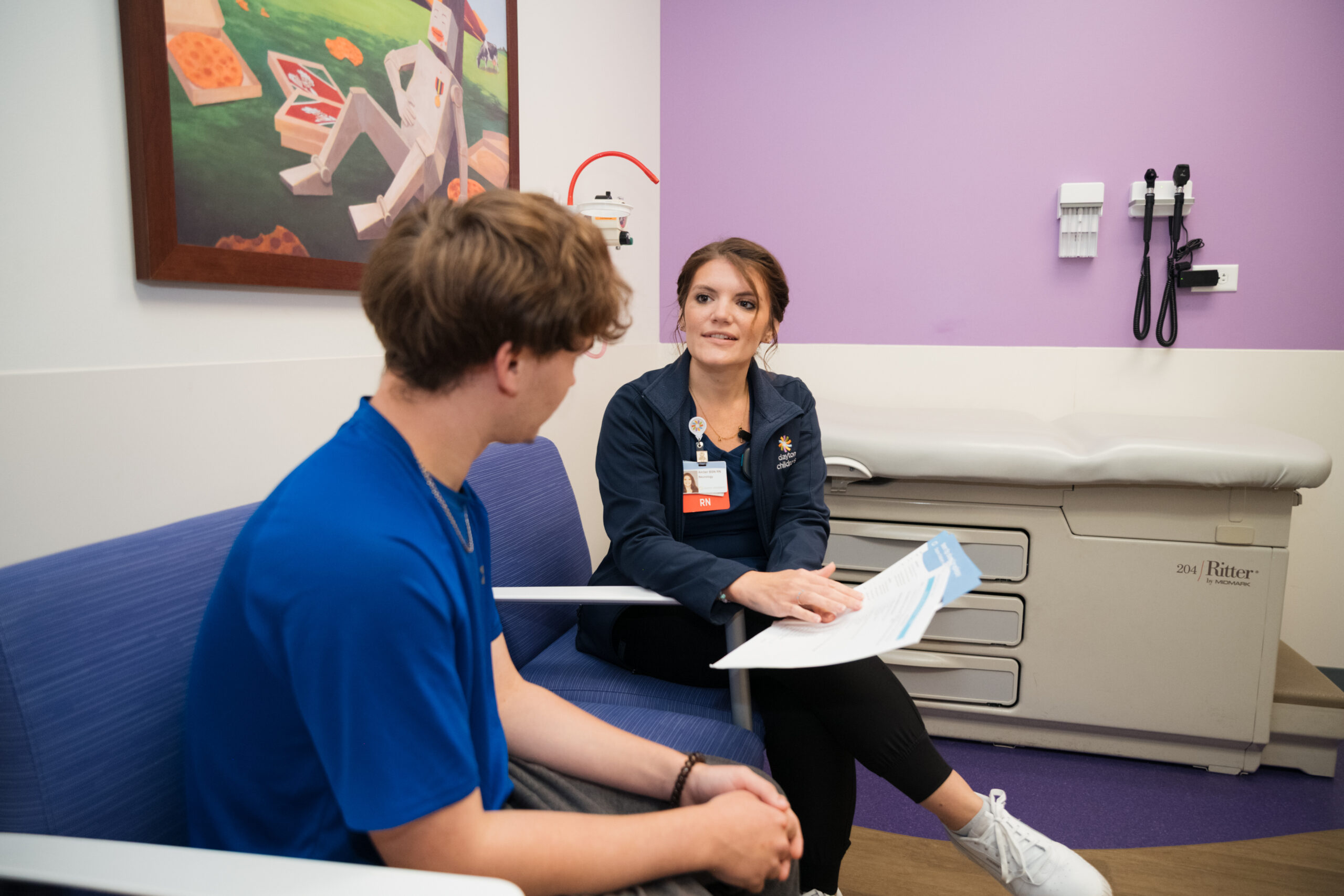 A nurse talks through education resources with a Dayton Children’s patient about their condition.