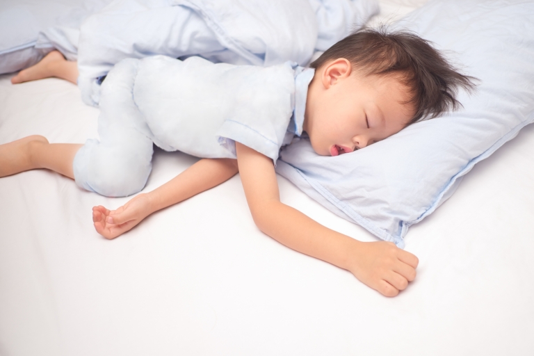 Boy toddler sleeping on a pillow with possible sleep apnea
