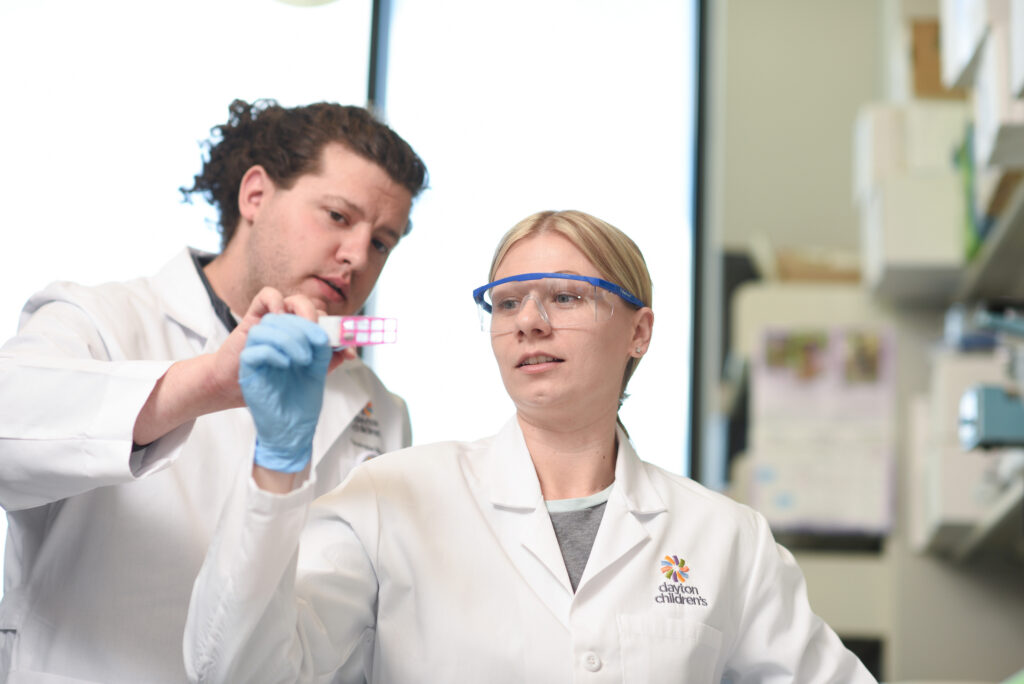Two researchers review test samples in a slide for research study.
