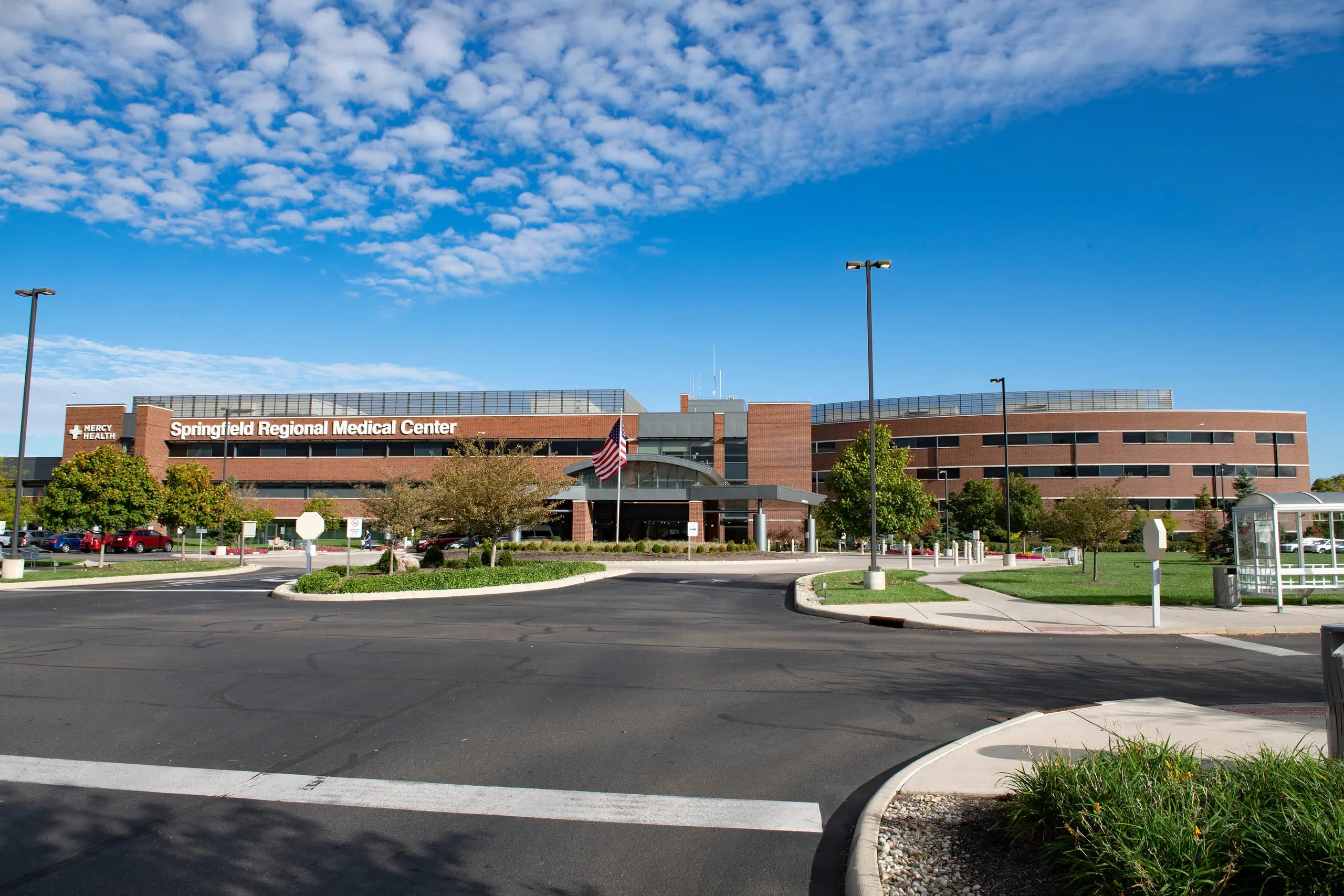 The large brick and glass building of the Springfield Regional Medical Center under a bright blue sky with scattered clouds.