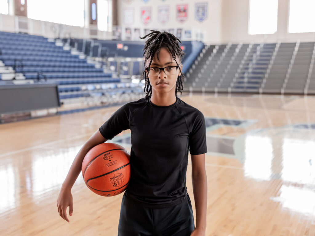 Teen basketball player focused while holding a basketball.