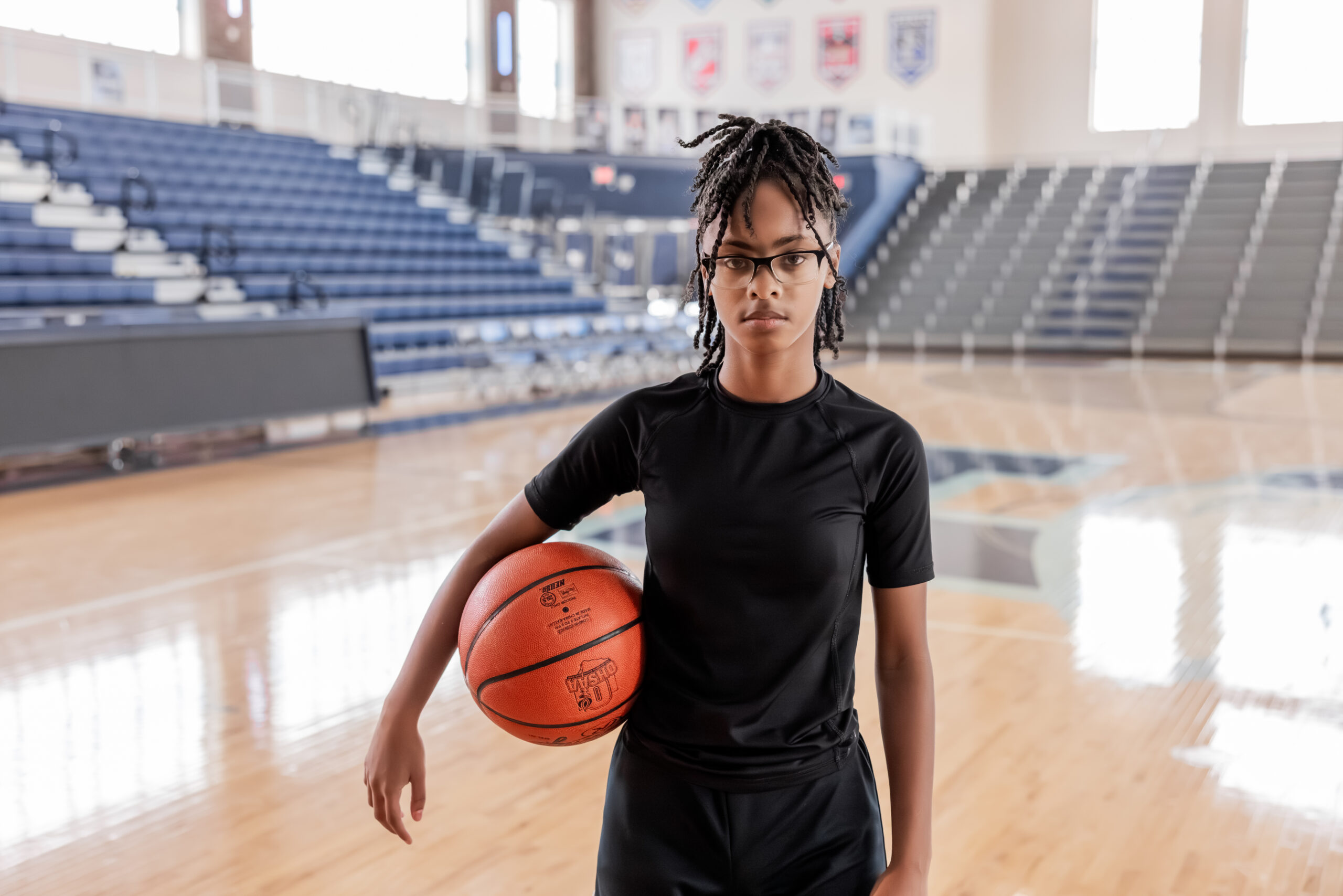 Teen basketball player focused while holding a basketball.