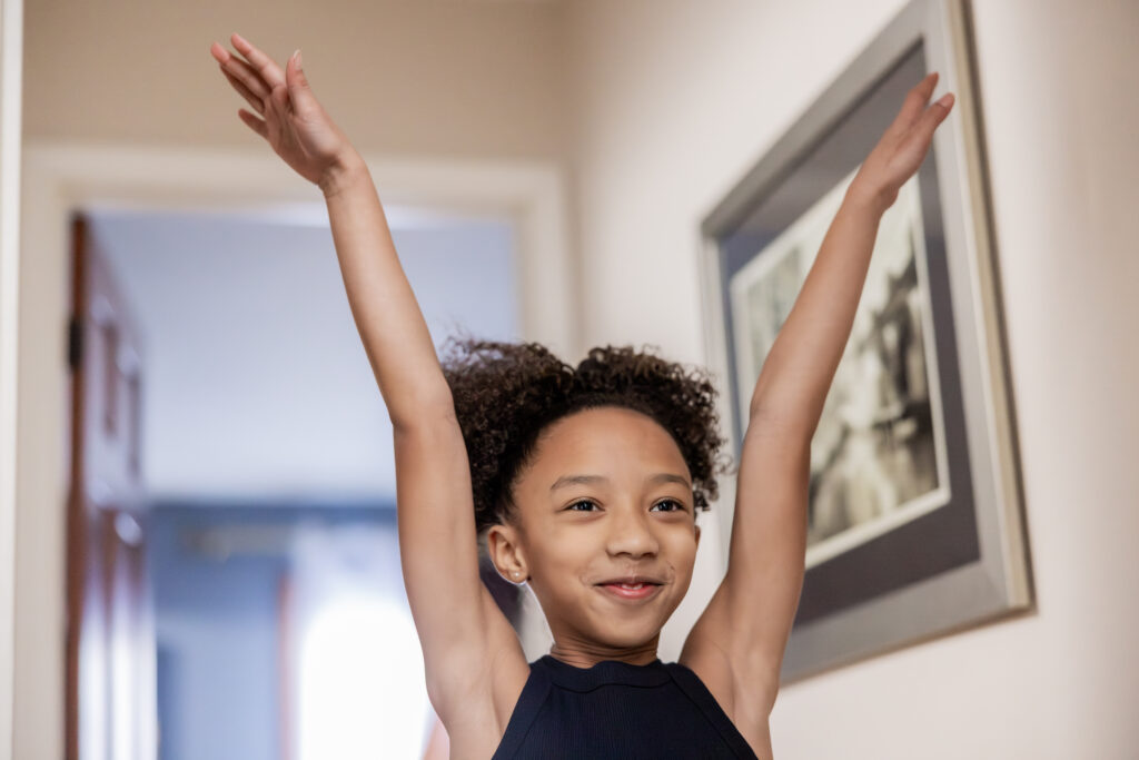 Young gymnast smiles confidently while practicing at home.