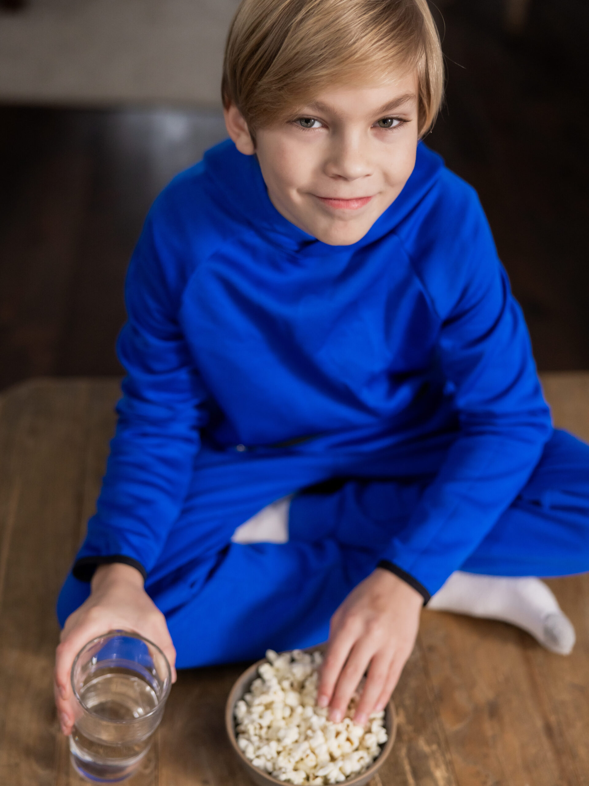 Young athlete eating a balanced snack and hydrating while at home and watching the Olympics.