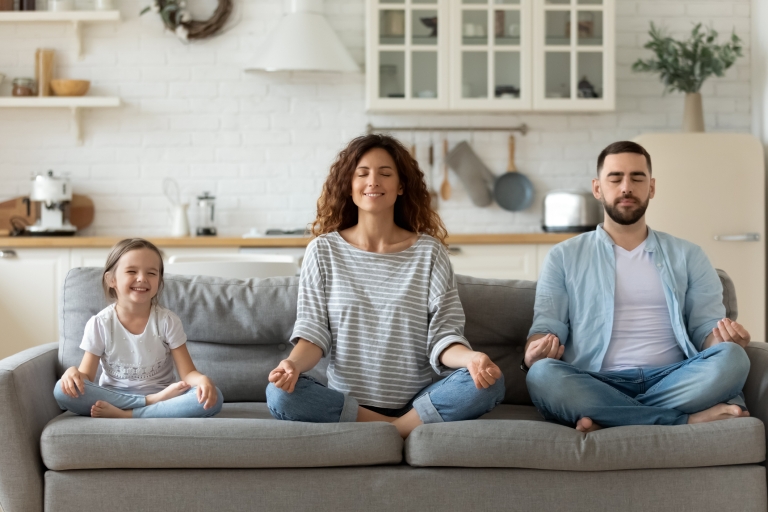 family with young daughter practice mindfulness in their home