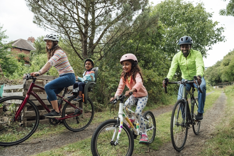 family biking together down nature trail