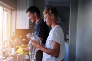 teenage son helps out by doing dishes