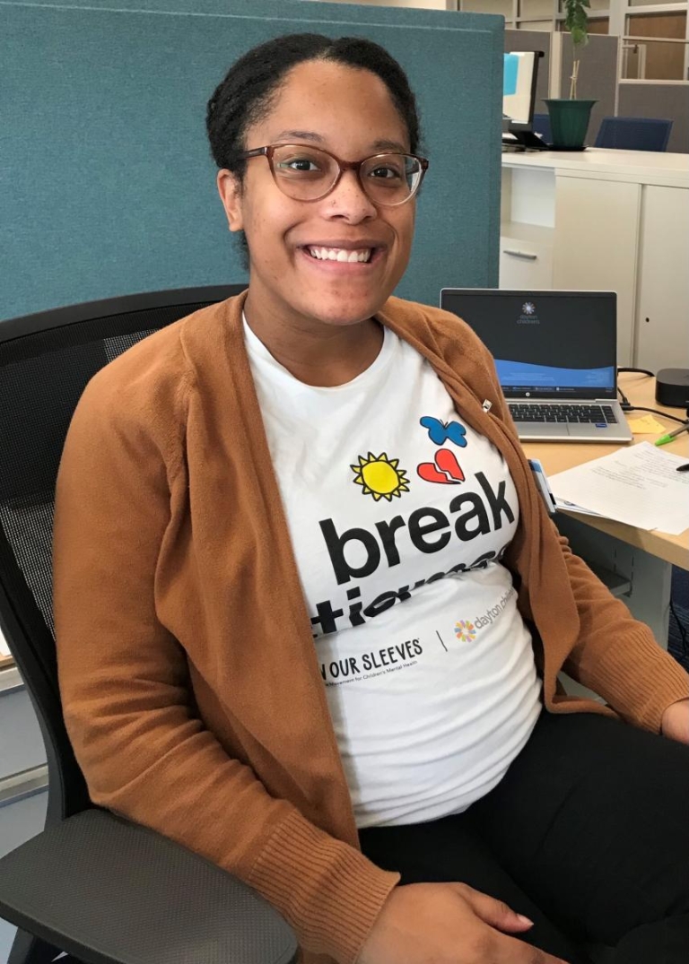 Unity Smith, Dayton Children's employee, poses with her On Our Sleeves shirt