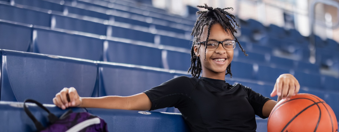teen basketball player holds basketball feeling like a champion