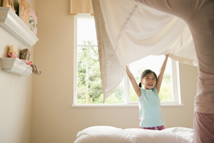 Young girl throws blanket into the air
